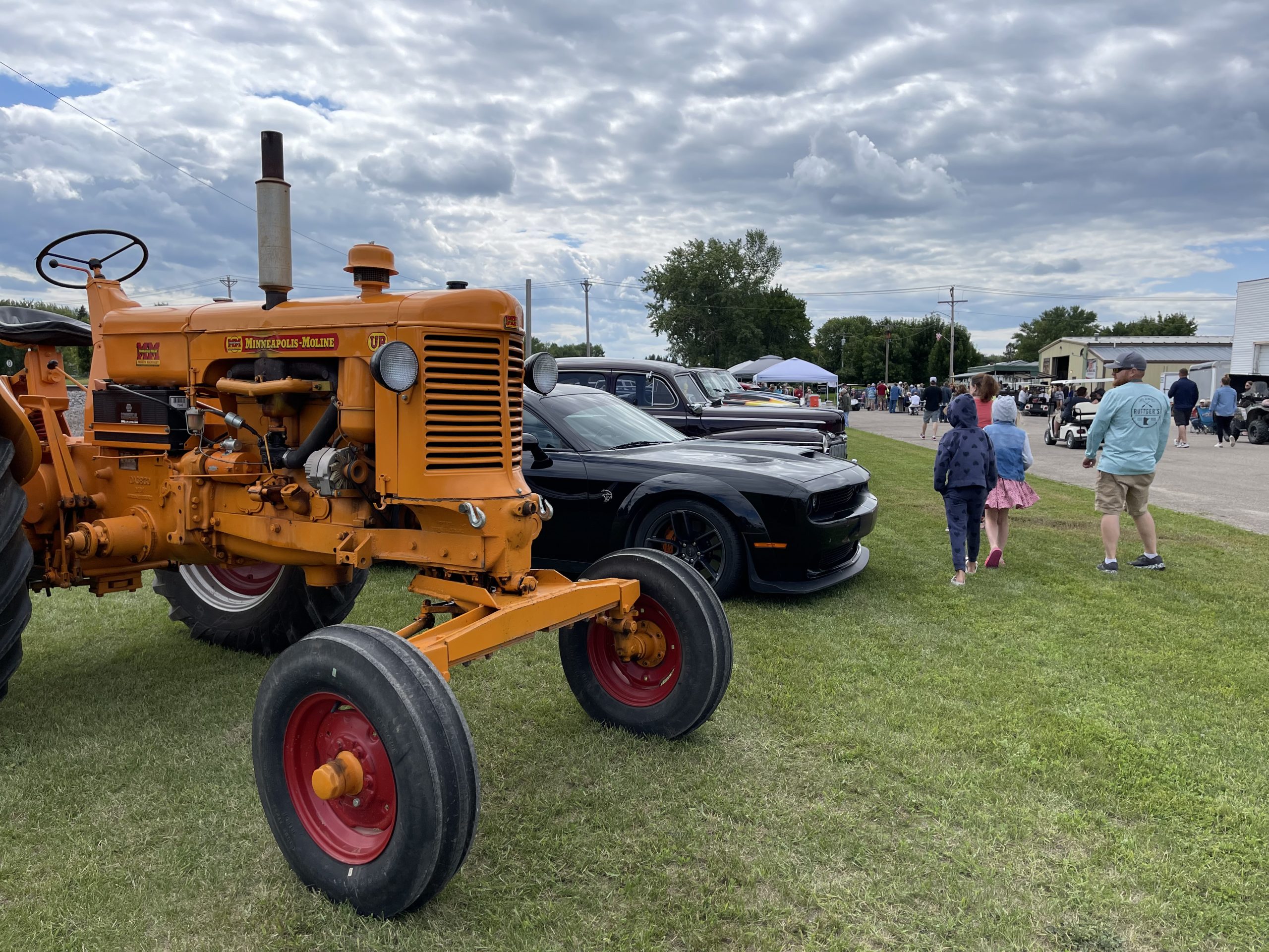 people viewing antique cars and tractors